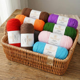 Basket filled with assorted BATELO acrylic yarn skeins in red, orange, purple, green, pink, and blue