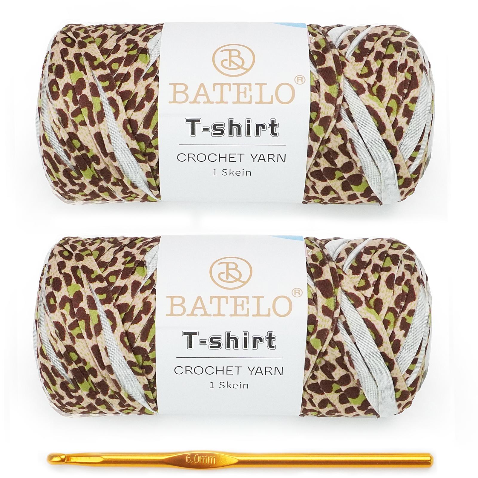 Two brown leopard-print BATELO T-shirt yarn skeins with a gold crochet hook on a white background