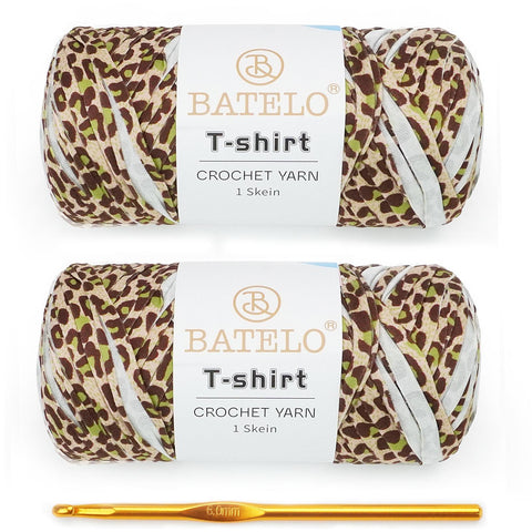 Two brown leopard-print BATELO T-shirt yarn skeins with a gold crochet hook on a white background