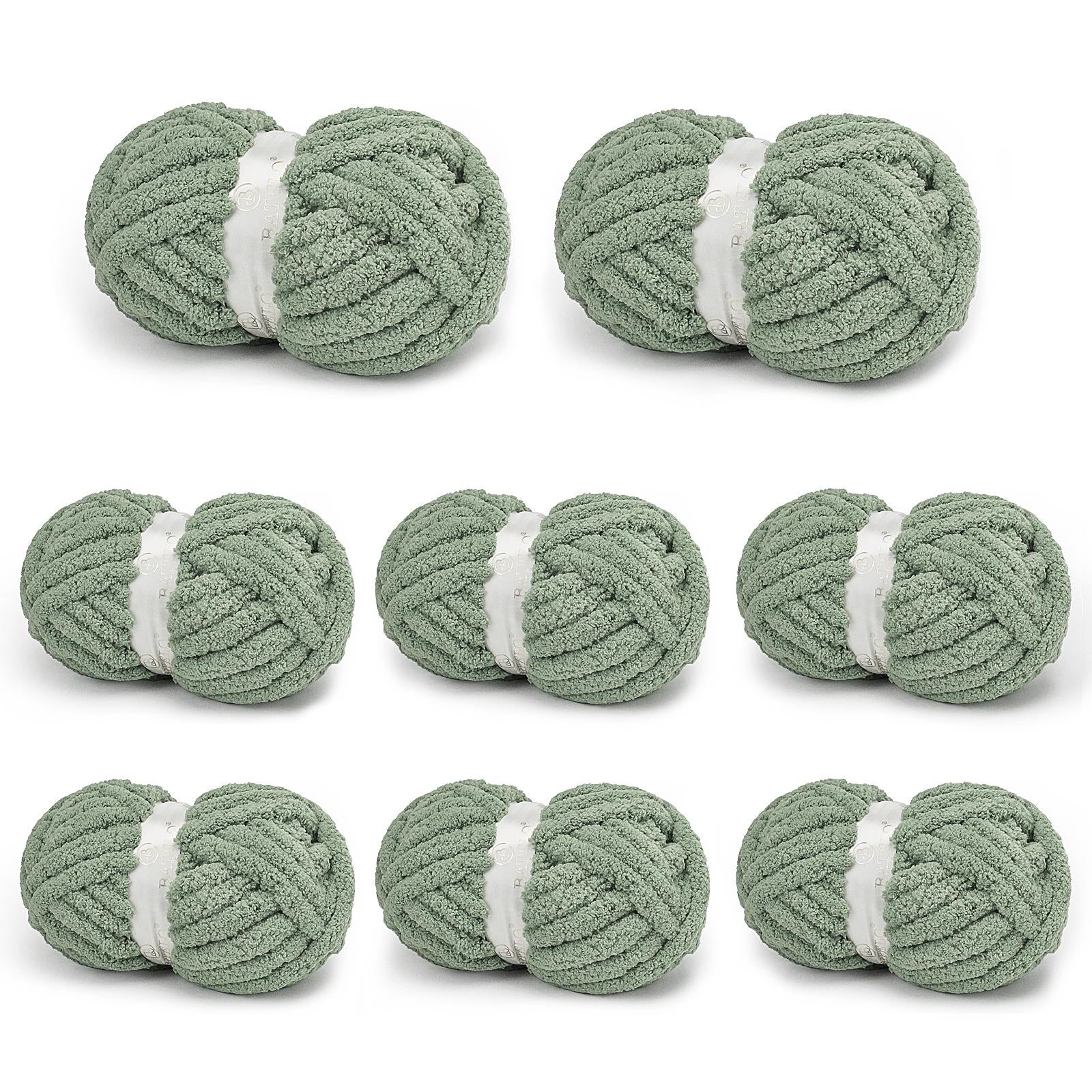 Eight sage gray BATELO chunky chenille yarn skeins arranged on a white background