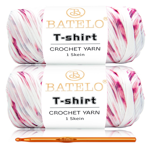 Two pink, black, and white variegated BATELO T-shirt yarn skeins with a gold crochet hook on a white background