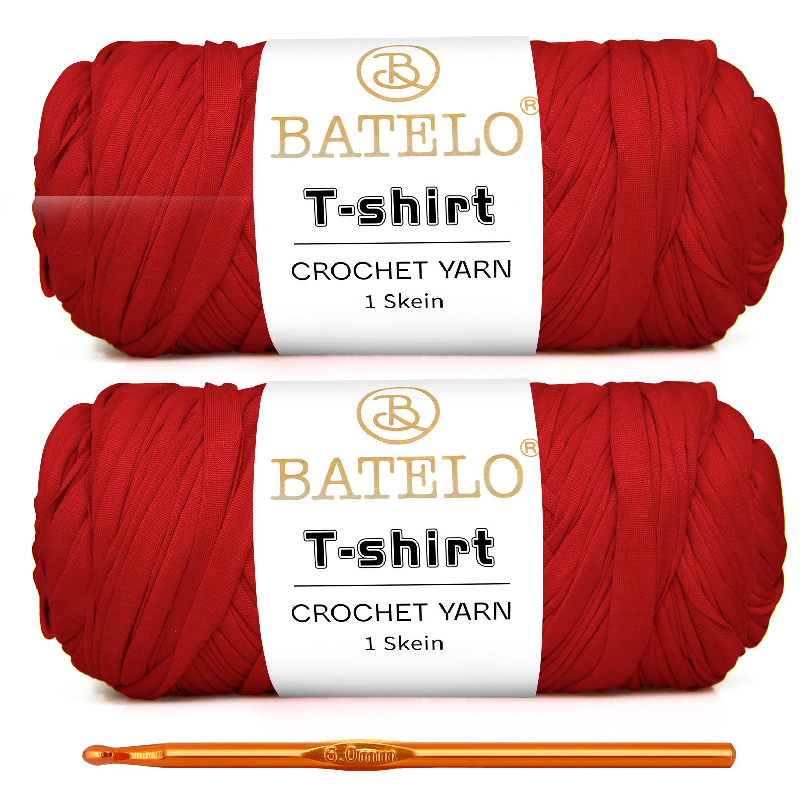 Two red BATELO T-shirt yarn skeins with a gold crochet hook on a white background