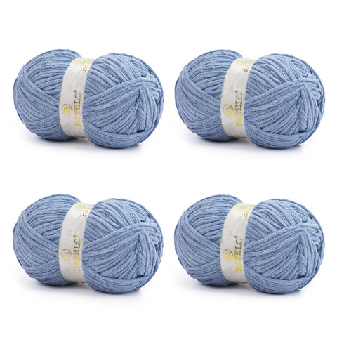 Four dusty blue BATELO bulky chenille blanket yarn skeins arranged on a white background