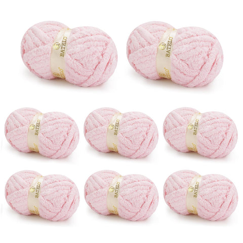 Eight pale pink BATELO chunky chenille yarn skeins arranged on a white background