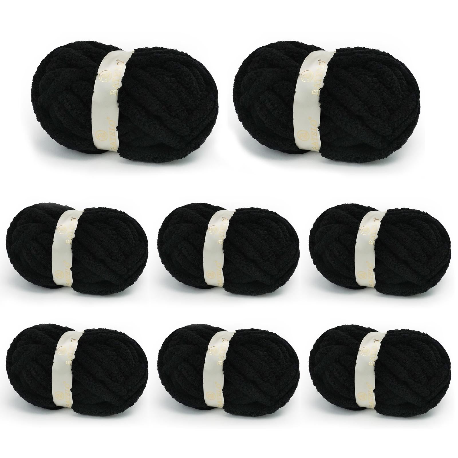 Eight black BATELO chunky chenille yarn skeins arranged on a white background