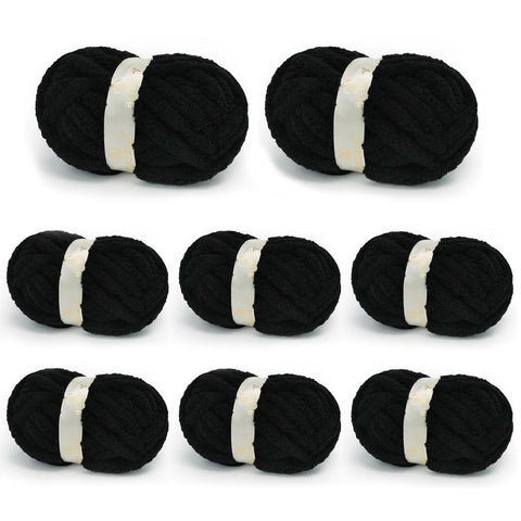 Eight black BATELO chunky chenille yarn skeins arranged on a white background