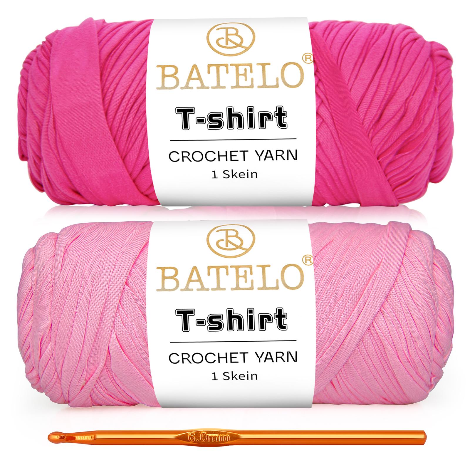 Two hot pink and light pink BATELO T-shirt yarn skeins with a gold crochet hook on a white background