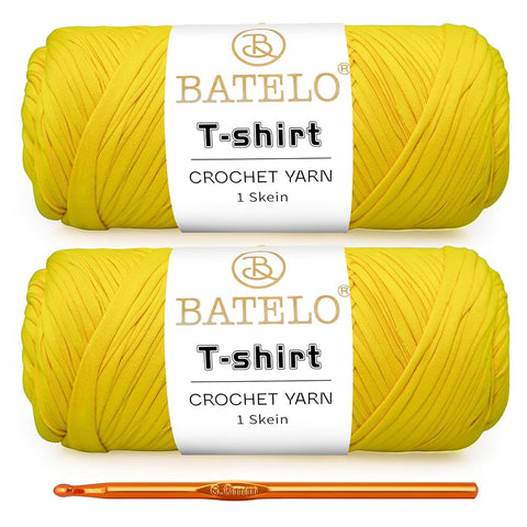 Two bright yellow BATELO T-shirt yarn skeins with a gold crochet hook on a white background