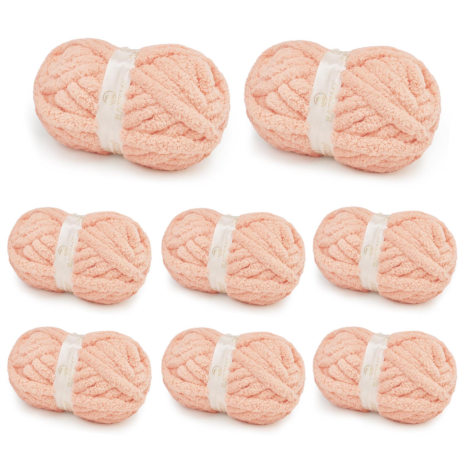 Eight blush peach BATELO chunky chenille yarn skeins arranged on a white background