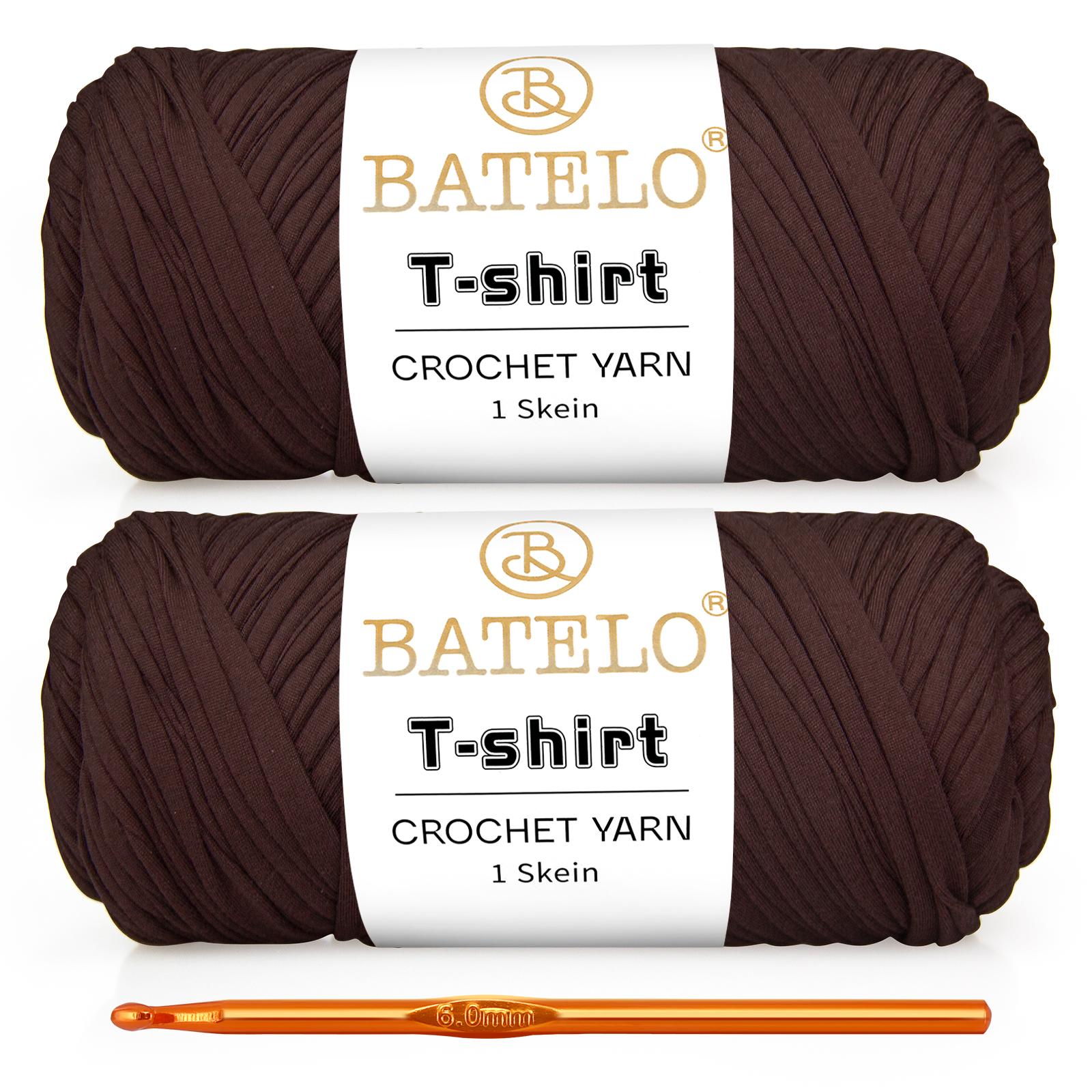 Two dark brown BATELO T-shirt yarn skeins with a gold crochet hook on a white background