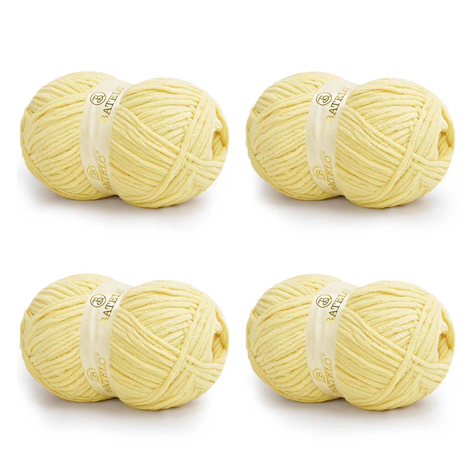 Four pale yellow BATELO bulky chenille blanket yarn skeins arranged on a white background