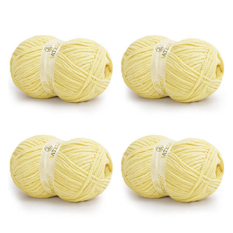 Four pale yellow BATELO bulky chenille blanket yarn skeins arranged on a white background