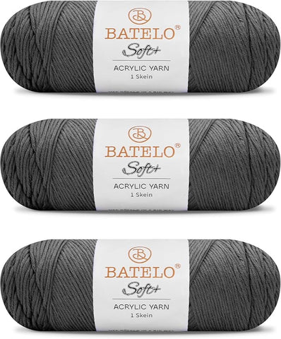 Three charcoal gray BATELO medium acrylic yarn skeins with white labels on a white background