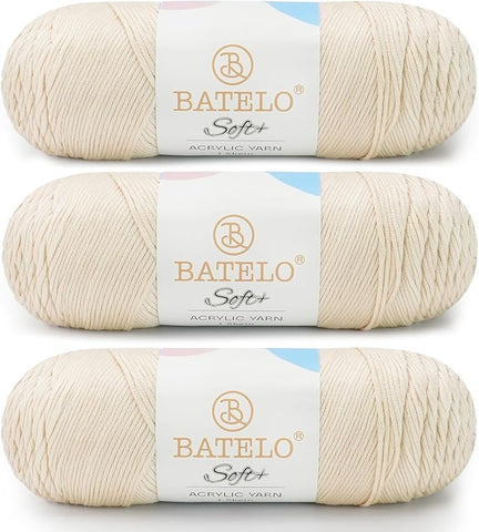 Three cream BATELO medium acrylic yarn skeins with white labels on a white background