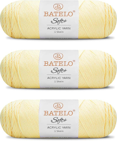 Three pale yellow BATELO medium acrylic yarn skeins with white labels on a white background
