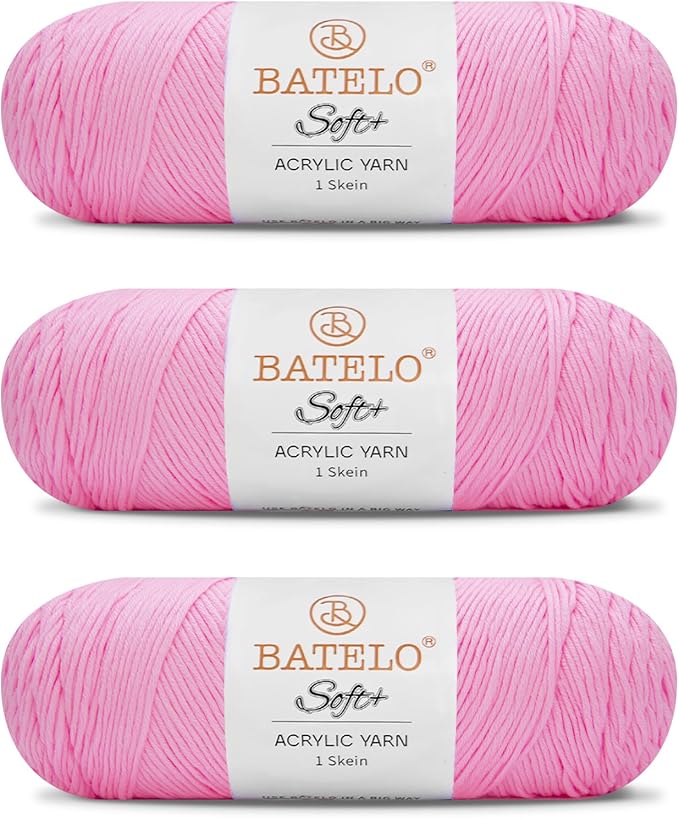Three light pink BATELO medium acrylic yarn skeins with white labels on a white background