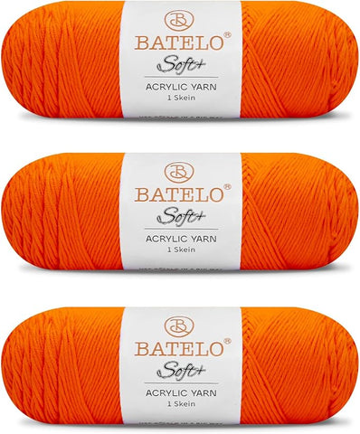 Three orange BATELO medium acrylic yarn skeins with white labels on a white background