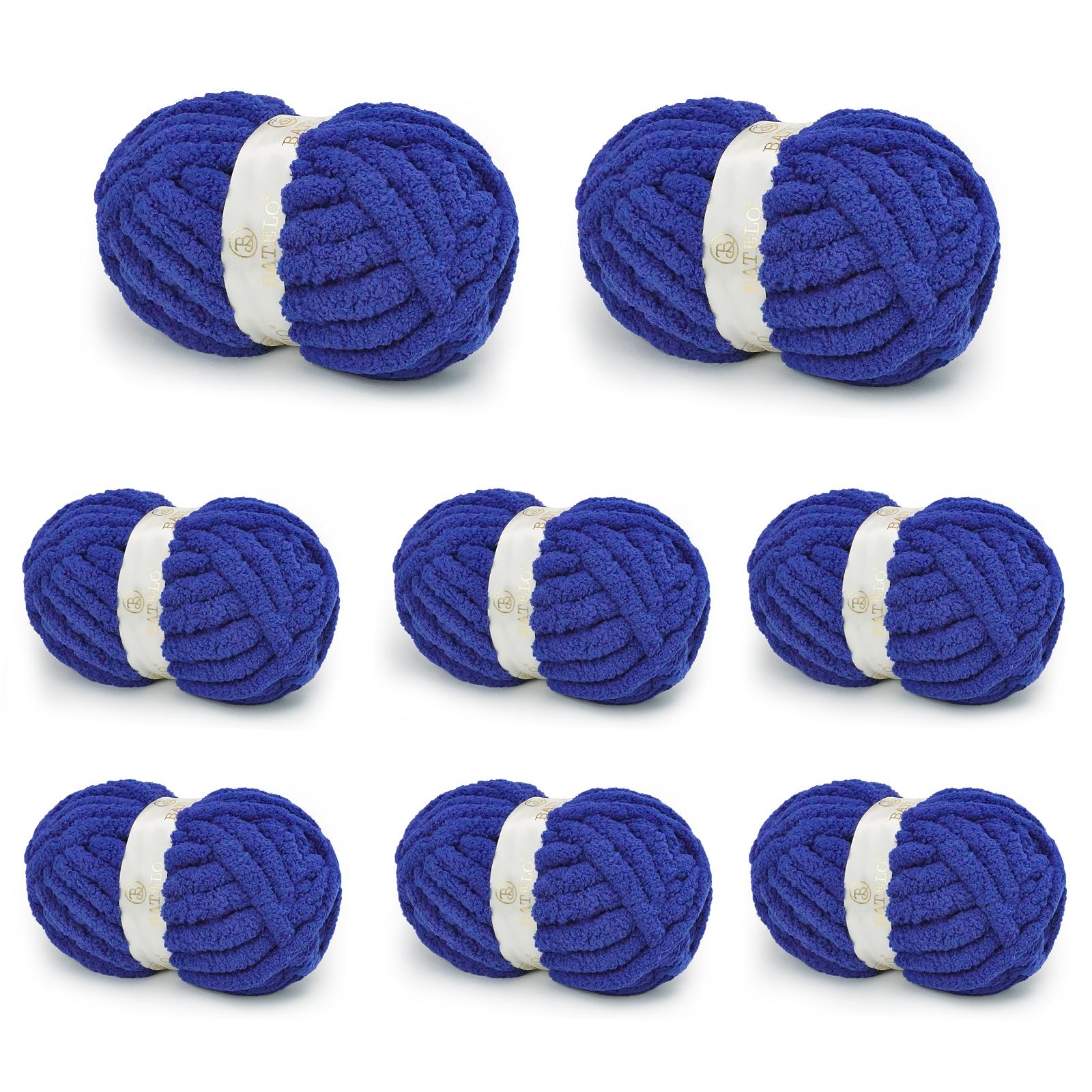 Eight royal blue BATELO chunky chenille yarn skeins arranged on a white background