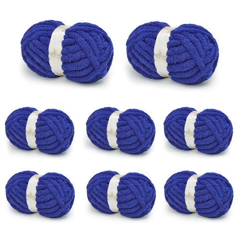 Eight royal blue BATELO chunky chenille yarn skeins arranged on a white background