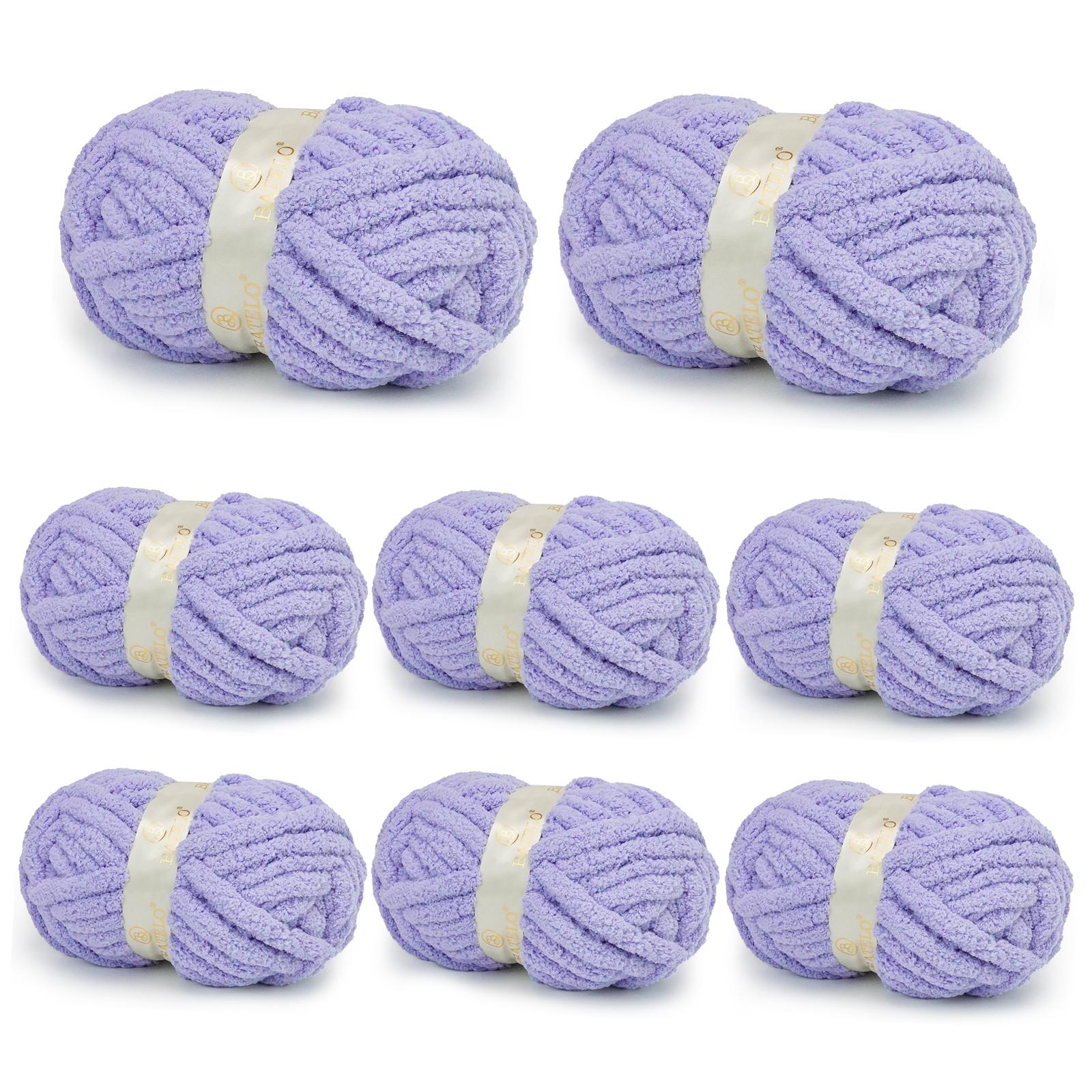 Eight lavender BATELO chunky chenille yarn skeins arranged on a white background