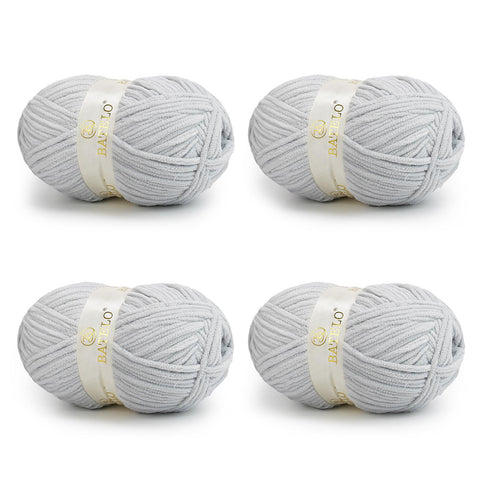 Four light gray BATELO bulky chenille blanket yarn skeins arranged on a white background