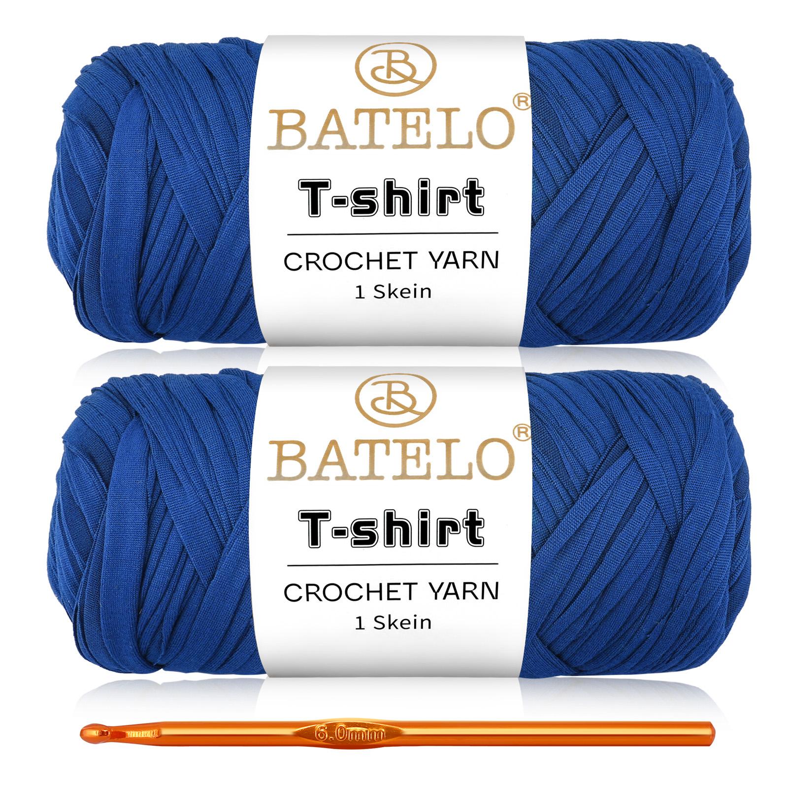 Two royal blue BATELO T-shirt yarn skeins with a gold crochet hook on a white background