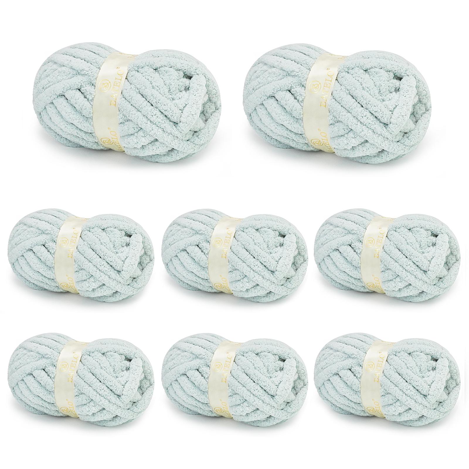 Eight pale blue BATELO chunky chenille yarn skeins arranged on a white background