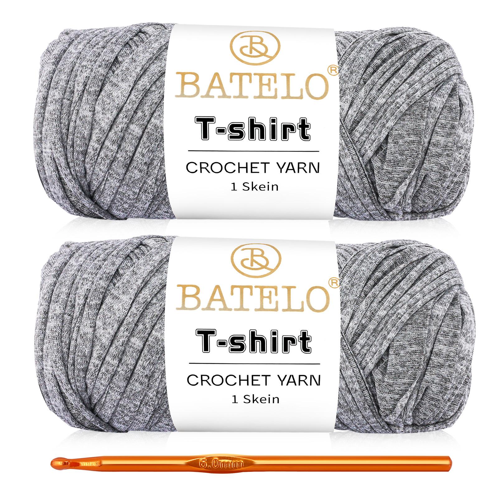 Two heather gray BATELO T-shirt yarn skeins with a gold crochet hook on a white background